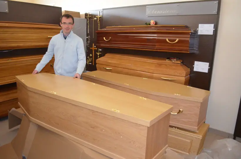 Cédric Gougeon près d'un cercueil écologique que rien ne distingue à première vue d'un classique