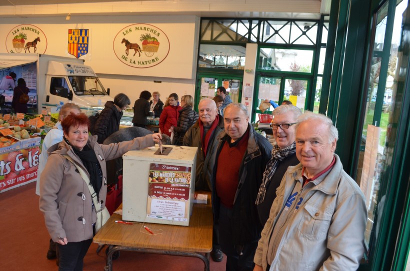 De droite à gauche : Christian Vincent, trésorier, Jean-Jacques Cocaud, président et les membres du bureau des Marchés de la Nature reçoivent les clients qui déposent leurs tickets dans l'urne